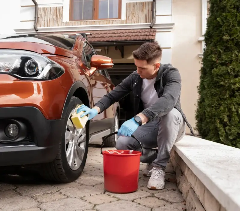 Lavage auto à domicile Saint-Gervais-en-Belin : professionnel intervenant sur un véhicule